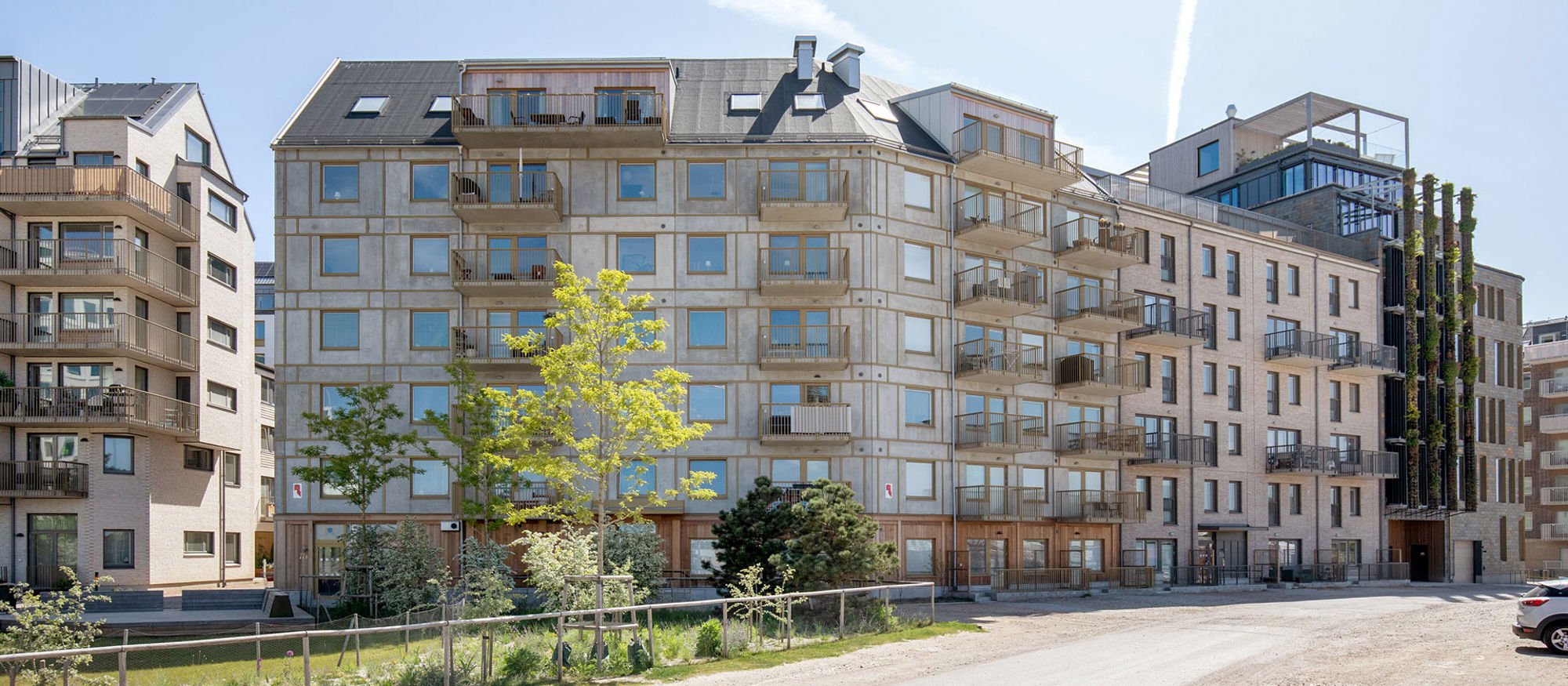 Foto av ett flerbostadshus med blå himmel i bakgrunden.