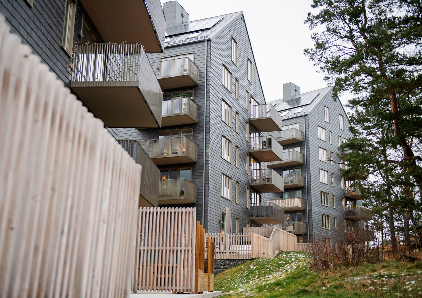 Foto av hus klädda i skiffer som bildar bostadsrätterna Kattugglan.