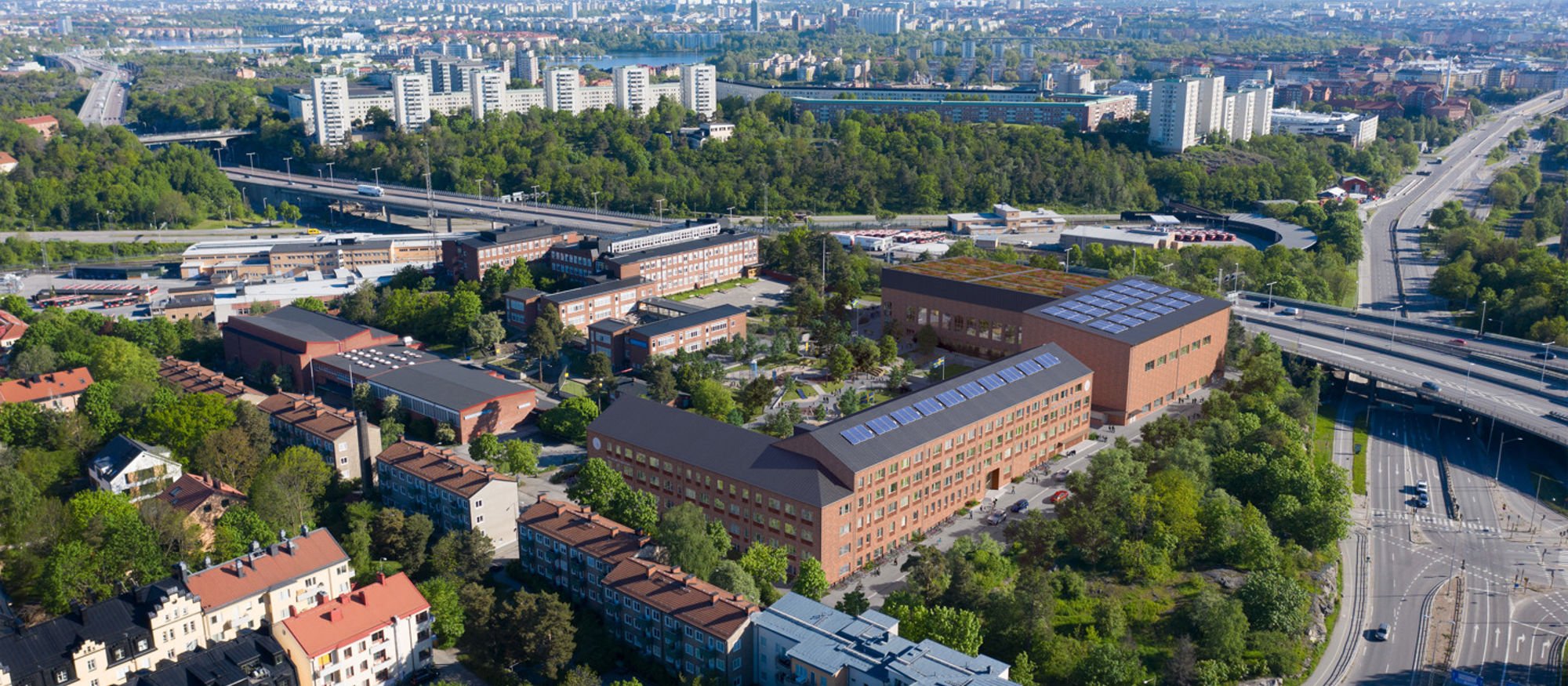 Sportanläggning i rött tegel nära motorväg