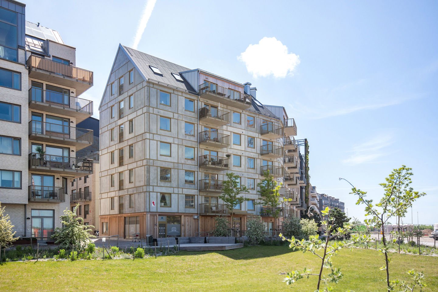 Foto av ett flerbostadshus med blå himmel i bakgrunden.